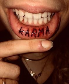 a woman holding her finger up to her mouth with the word karma written on it