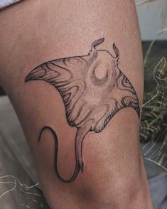 a woman's thigh with a tattoo of a stingfish on the side,