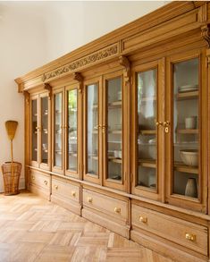 a wooden china cabinet with glass doors and gold trimmings on the top shelf