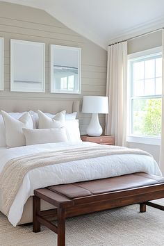 a bed with white linens and pillows in a bedroom next to two lamps on either side of the bed