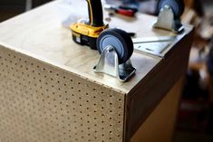 two tools are sitting on top of a piece of plywood workbench that is being worked on