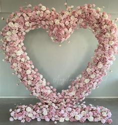 a heart made out of pink and white flowers in the shape of a flower arrangement