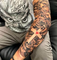 a man with a cross and roses tattoo on his arm