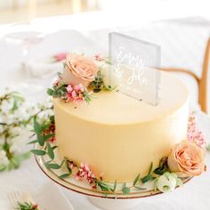 there is a cake with flowers on the top and a place card in the middle