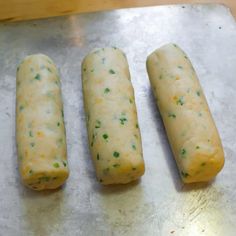 three pieces of bread sitting on top of a metal tray next to eachother