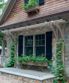 an old stone house with ivy growing on the windows