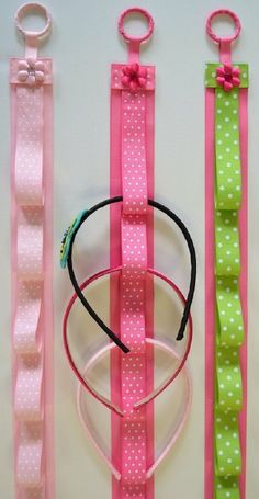 three pink and green hair ties, one with a bow on the end are lined up next to each other