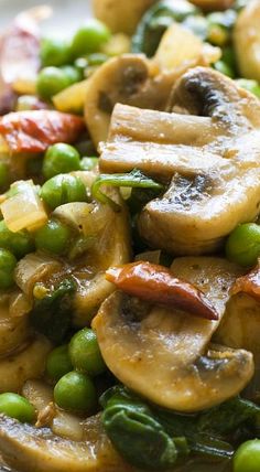 a white plate topped with peas and mushrooms