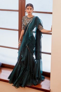 Teal green pre-draped saree with embroidered border and ruffle detailing. Comes with sheer neckline blouse.
Component: 2
Embroidered
Neckline: Round
Sleeve Length: Elbow
Fabric: Georgette
Color: Green
Mirror, resham, cutdana and sequin embroidery
Embroidered blouse
Sheer neckline and back - Aza Fashions Saree With Ruffles, Organza Drape Saree, Fashion Sarees Style, Green Ruffle Saree, Sari Modern, Mirror Work Border, Ruffled Saree, Indian Bridesmaids, Stitched Saree