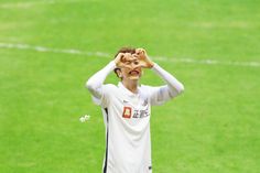 a young man holding his hands up to his face while standing on a soccer field