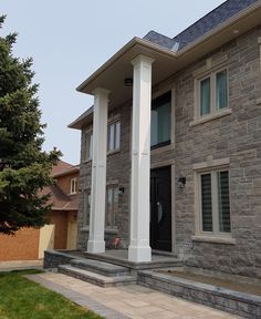 a large house with stone pillars and windows