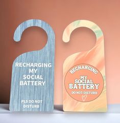 two wooden door hangers that say recharging my social battery and not disturb