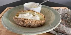 a piece of bread on a plate with whipped cream in it and a cup of yogurt