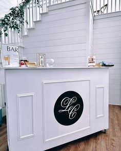 a white bar with a black monogrammed sign on it's front door