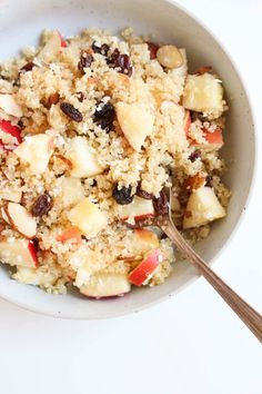 a white bowl filled with fruit and oatmeal on top of a table