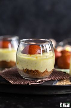 two desserts in small glass dishes on a table with other food items around them