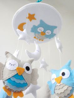 two stuffed owls are hanging from strings in the shape of stars and moon mobiles