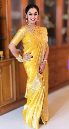 a woman in a yellow sari posing for the camera