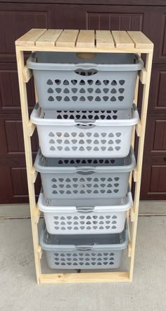 three plastic baskets stacked on top of each other in front of a garage door with brown shutters