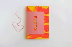 a notebook with the word love written on it next to a pair of pink string