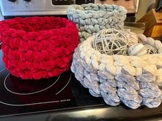 three balls of yarn sitting on top of an oven