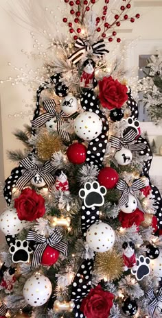 a christmas tree decorated with black and white polka dots, red roses, and paw prints