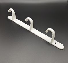 a pair of white coat hangers sitting on top of a black table next to each other