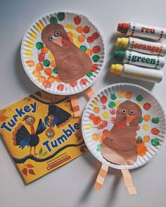 three paper plates with turkeys on them next to crayon sticks and markers