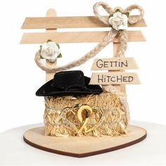 a wooden sign with a hat and sunglasses on it that says gettin hitched