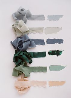 several different colors of paper on a white surface with one torn off and the other unrolled