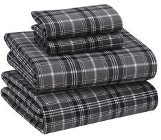 three plaid sheets stacked on top of each other in black and white colors, with one folded