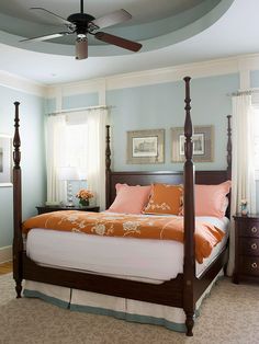 a bed room with a neatly made bed and a ceiling fan in the middle of it