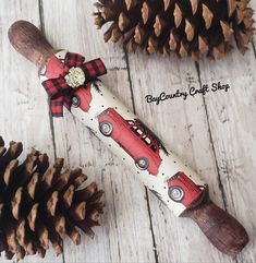 a pine cone with a red car design on it next to a wooden stick and some cones