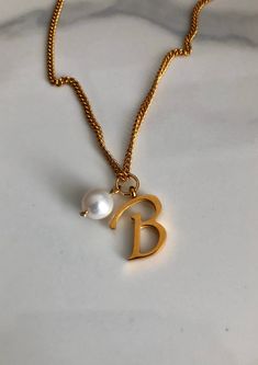 Letter B necklace, set on a stainless steel ,golden color chain. With addition cost there is an option to add a white freshwater pearl, as a charm, next to the letter. 6 mm, white round pearl Kindly choose your option. Beautiful spiritual gift. chain length 18'. Please make sure you to pay attention to the size of the pendant. I have added pictures next to 25 cent coin, and measurement tape.  Need a different length just write it to me in the "message to the seller" box of the order form. **LIMI Personalized Pearl Necklace With Initial Pendant As Gift, Gold Dainty Pearl Necklace With Initial Pendant, Dainty Gold Pearl Necklace With Initial Pendant, Initial Necklace With Pearl Pendant For Gift, Initial Pendant Necklace With Pearl For Gift, Elegant Initial Necklace With Pearl Charm As Gift, Elegant Initial Necklace With Pearl Charm For Gifts, Pearl Pendant Initial Necklace As Gift, Dainty Pearl Necklace With Initial Pendant Gift