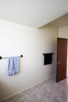 a bathroom with two towels hanging on the wall and a door in the corner that leads to another room