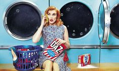 a woman sitting in front of a dryer talking on a cell phone