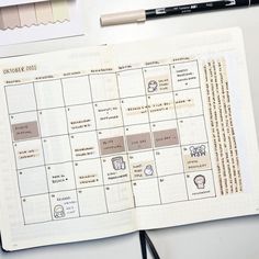 an open planner is sitting on a desk