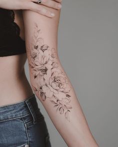 a woman's arm with a flower tattoo on the left side of her body