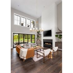 a living room filled with furniture and a flat screen tv mounted on the wall above a fireplace