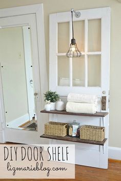 a shelf with towels and baskets on it in front of a door that is open