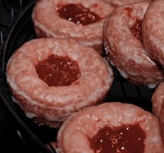 several donuts covered in powdered sugar sit on a cooling rack and are ready to be eaten