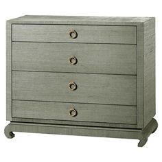 a grey dresser with three drawers and two handles on each drawer, against a white background