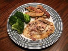 a plate with meat, broccoli and other food on it sitting on a wooden table