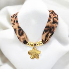 Leopard Necklace with Stainless Steel Gold Pendant: Wild Elegance Add a touch of wild glamour to your outfit with this beautiful leopard print inspired necklace. Made from a soft and lightweight fabric, this necklace is enhanced by a stainless steel pendant, available in two unique designs: a delicate flower or a radiant sun. Why adopt it? Unique and Trendy: Leopard print is timeless, perfect for those who dare to assert their style. Versatile: Ideal for a chic and bold look, whether for an even Luxury Gold-tone Elegant Charm Necklaces, Leopard Jewelry, Trendy Leopard Print Dangle Jewelry, Collier Art Floral, Leopard Necklace, Charms Necklace, Inspired Necklace, Gift For Her Birthday, Stainless Steel Pendant