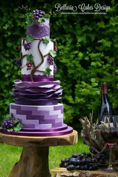 a three tiered cake with grapes on it