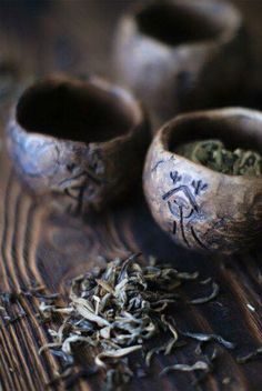 two wooden bowls filled with green tea on top of a table