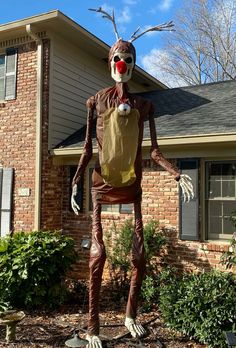 a scarecrow is standing in front of a house