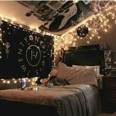 a bed room with a neatly made bed and lots of lights on the wall above it