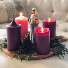 a nativity scene with candles and pine cones on a table in front of a couch