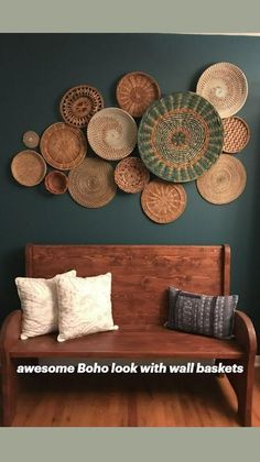 a wooden bench sitting in front of a wall with baskets hanging on it's side